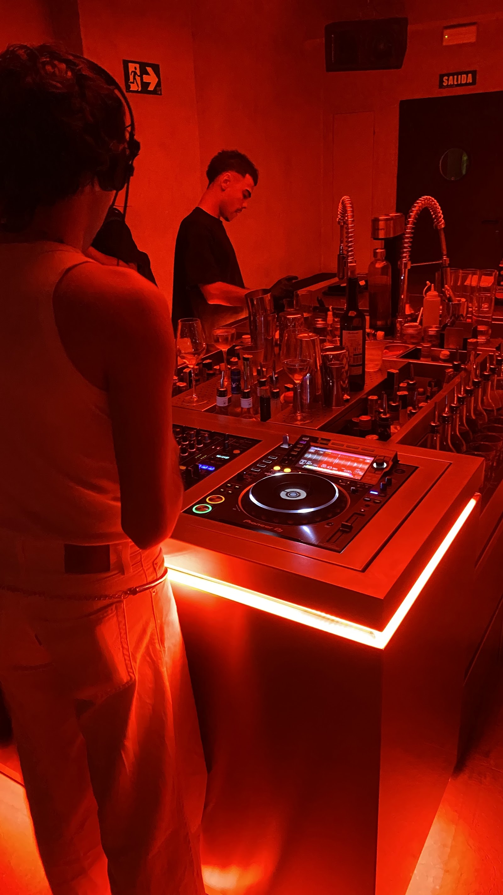Booth de DJ con neón morado en el interior de Kinki Cocktail Club
