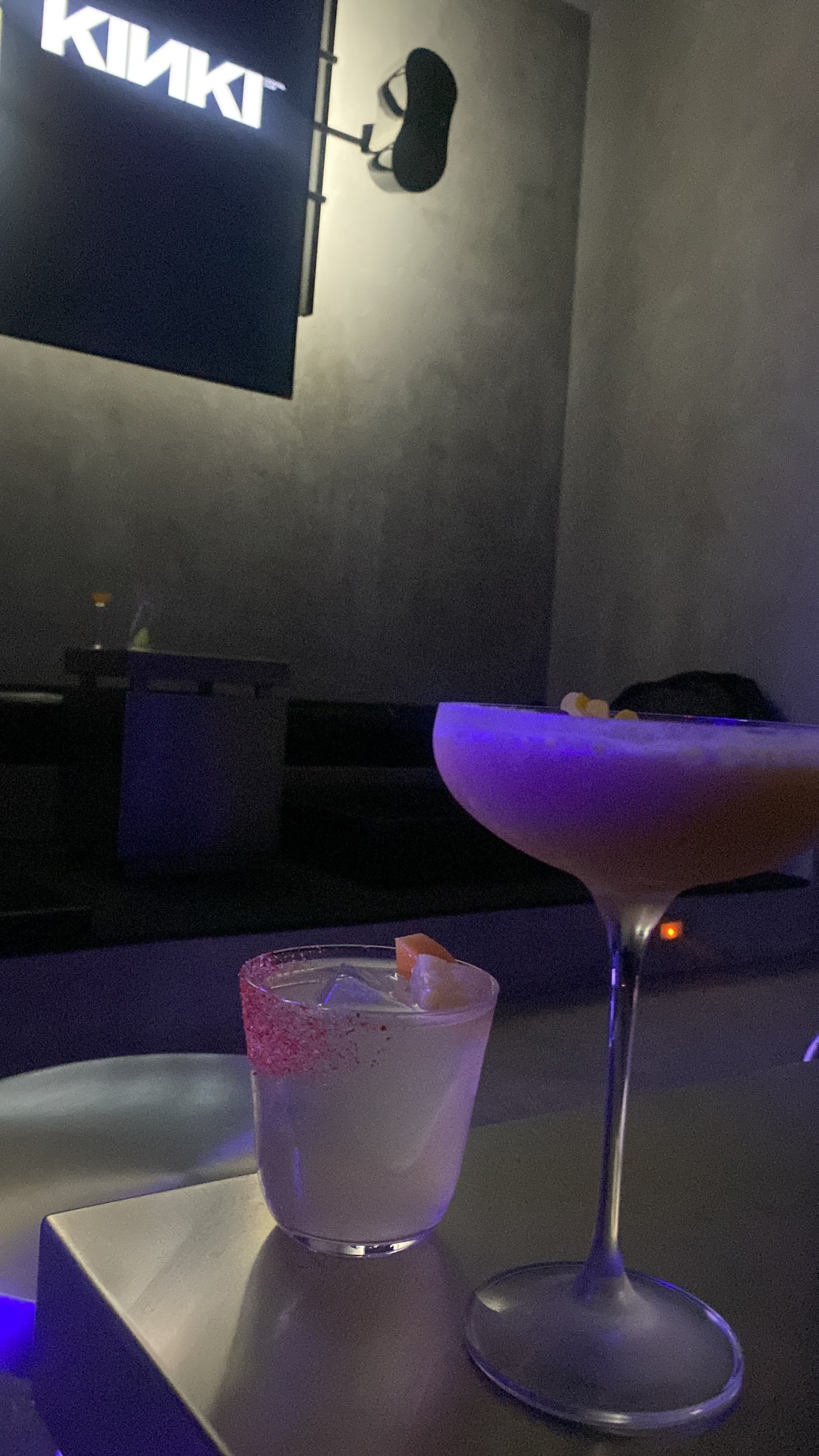 KINKI signage with two cocktails under purple ambient lighting at the bar
