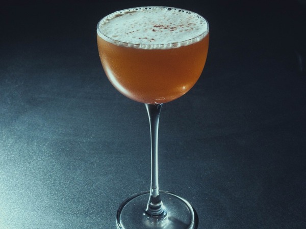 Pure Gold Espresso cocktail — amber tones, coupe glass, dark background