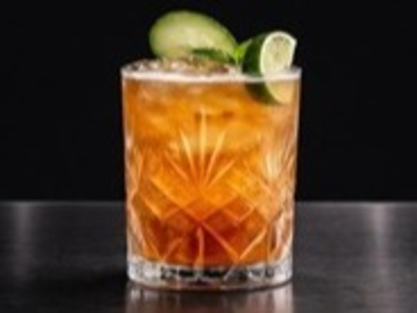 Jägermeister Mule — tumbler con ámbar y lima sobre fondo oscuro