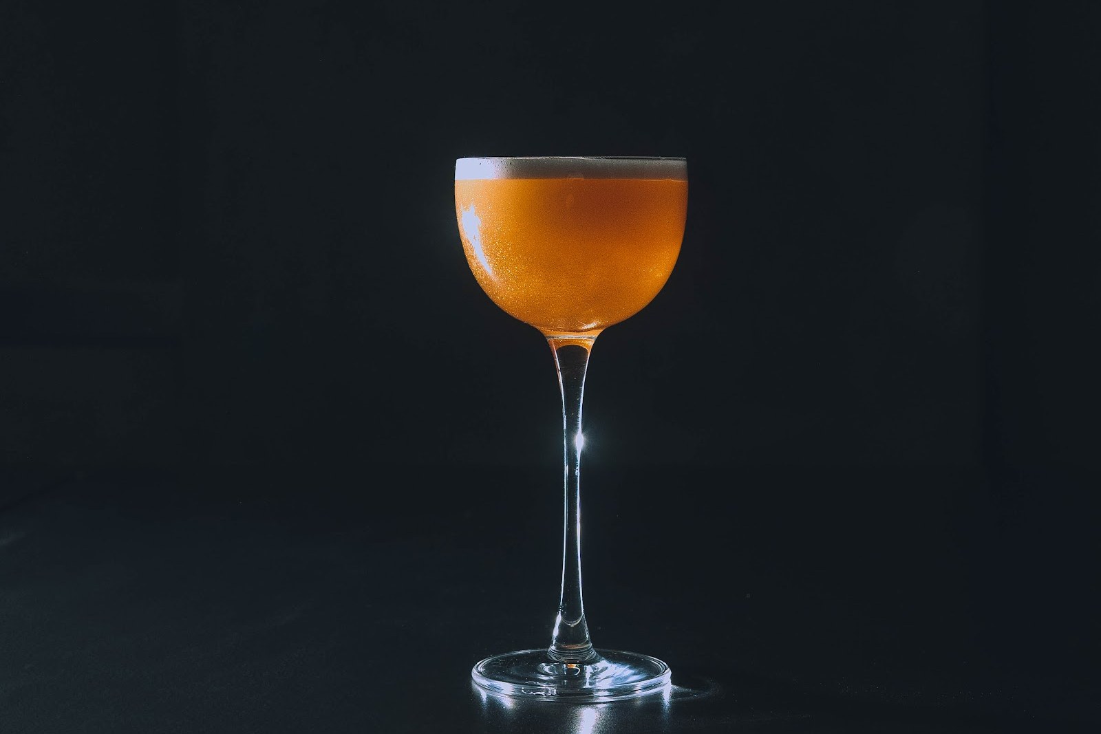 Cocktail served at KINKI Cocktail Club, dimly lit bar atmosphere in Malasaña Madrid