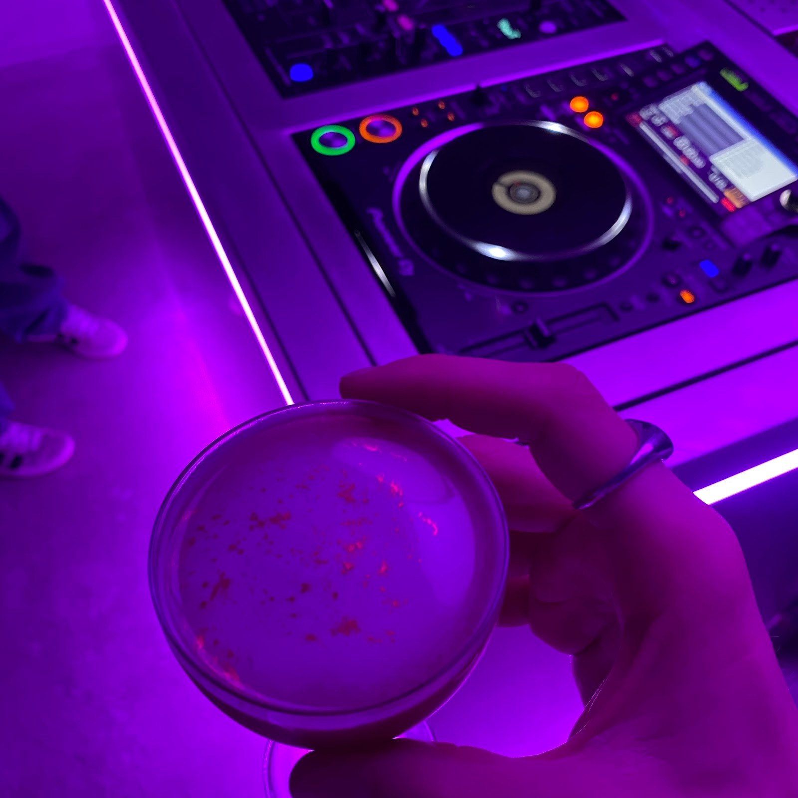 Crystal ball under purple neon with DJ equipment in the background at KINKI Cocktail Club