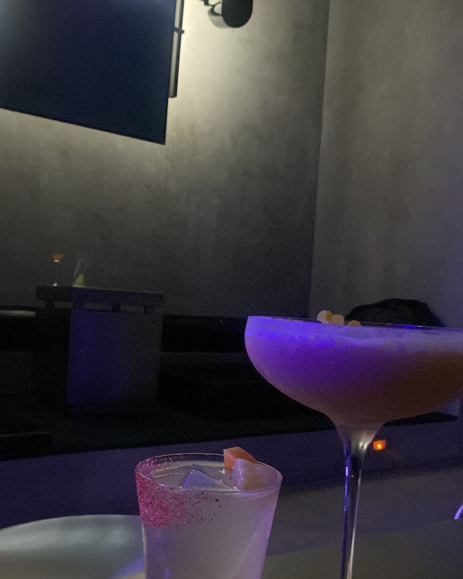 KINKI DJ booth and bar — purple and gold neon lighting over industrial dance floor