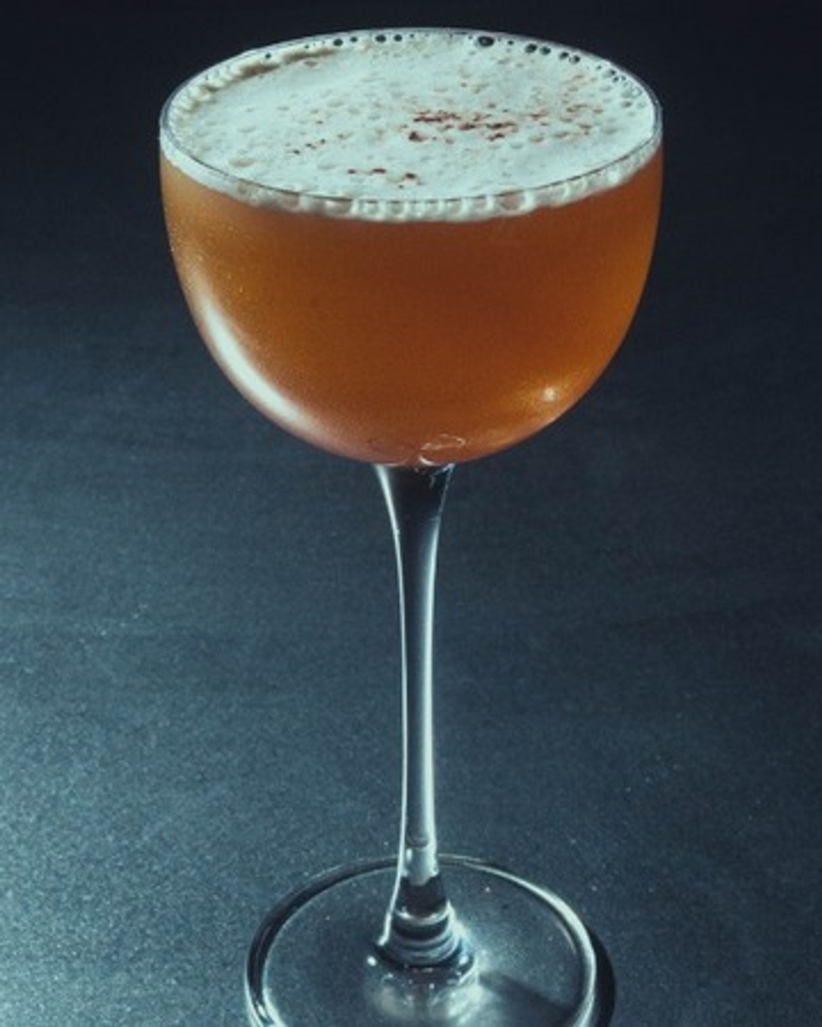 Pure Gold Espresso cocktail with amber foam, dramatic side lighting