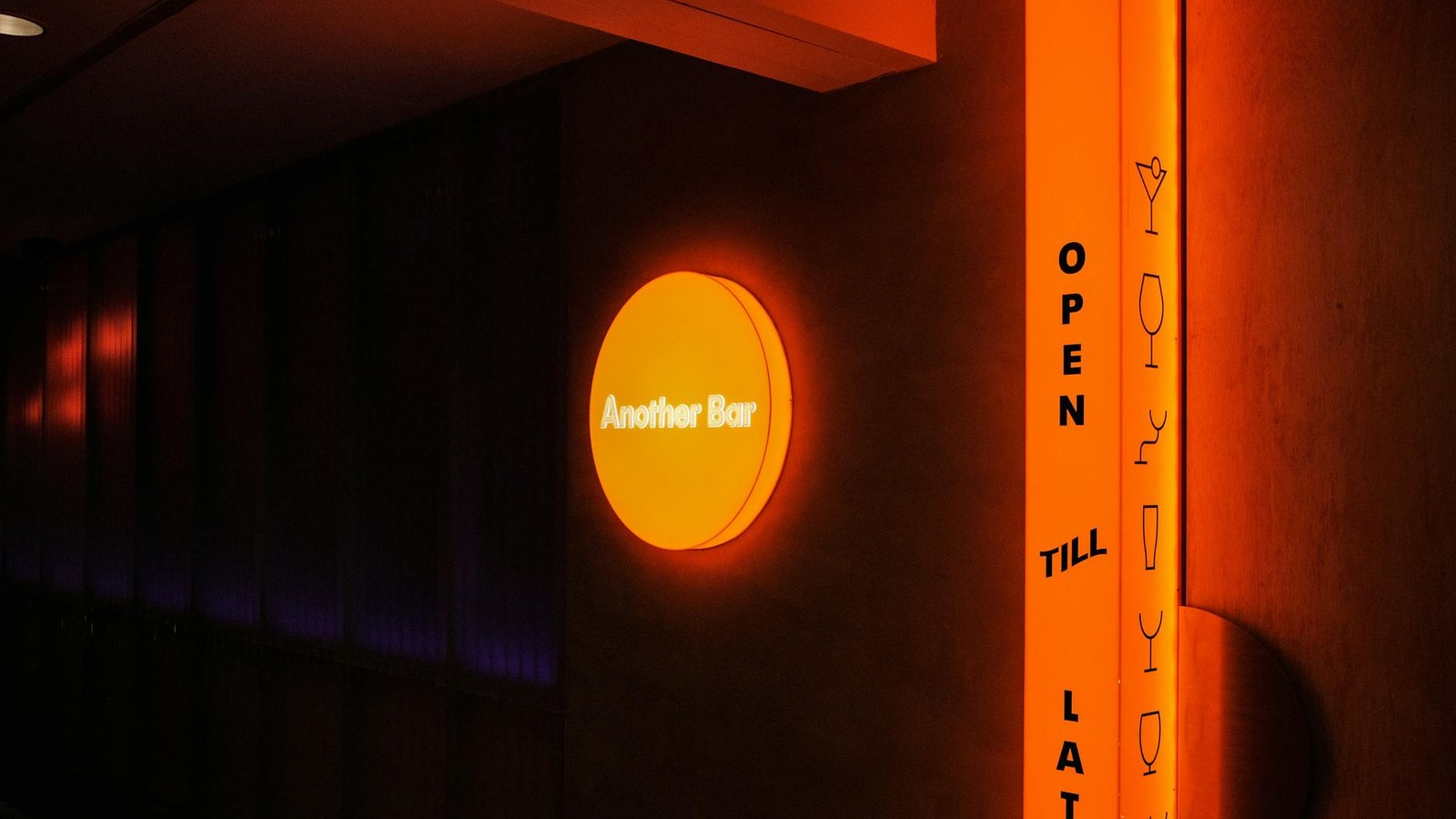 Interior of an intimate cocktail bar with neon ambient lighting at night