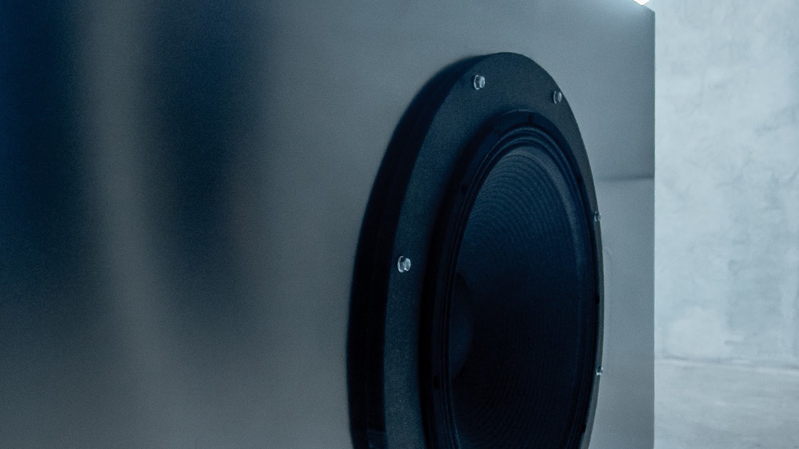 Altavoz minimalista en pared de hormigón, espacio industrial de KINKI Cocktail Club